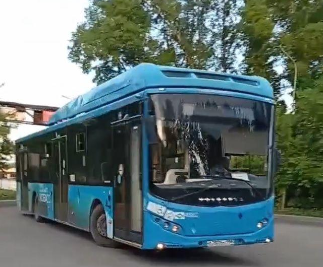 Синий городской автобус «Питеравто» уезжает с остановки общественного транспорта в Новокузнецке.