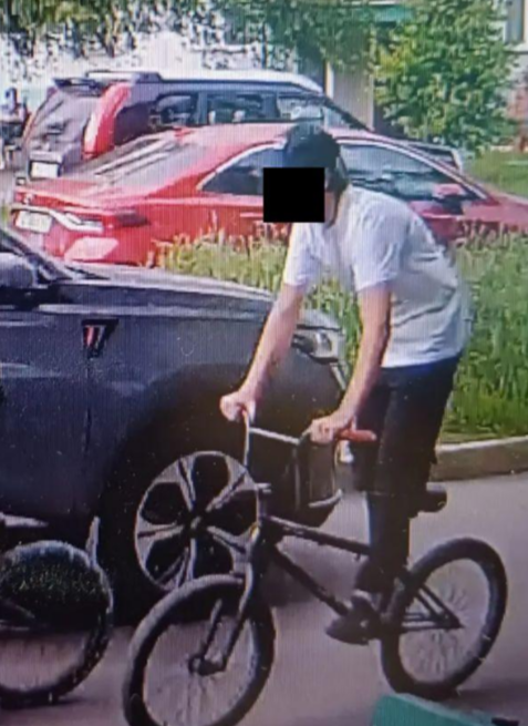 Скриншот с камеры наружного наблюдения во дворе жилого дома в Новокузнецке, где запечатлены передвигающиеся на велосипедах подростки