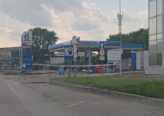 Закрытая автоматическая заправочная колонка с информационным объявлением и сигнальной лентой на въезде