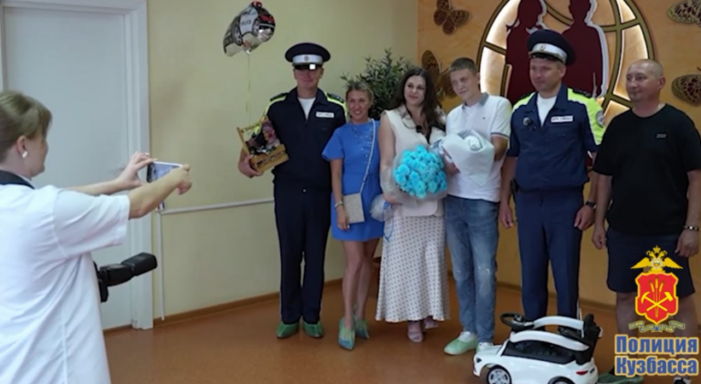 Патрульный автомобиль Госавтоинспекции с включенной световой и звуковой сигнализацией движется по загородной трассе.