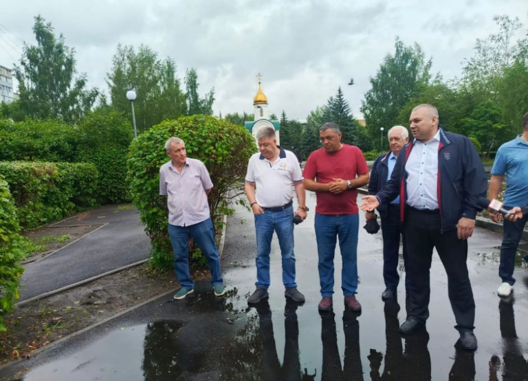 Глава Новокузнецка Денис Ильин осматривает качество укладки асфальтового покрытия в сквере во время дождя