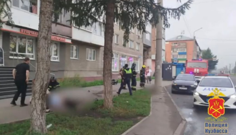 Опрокинутый спортивный кроссовый мотоцикл на тротуаре рядом с поврежденной опорой освещения