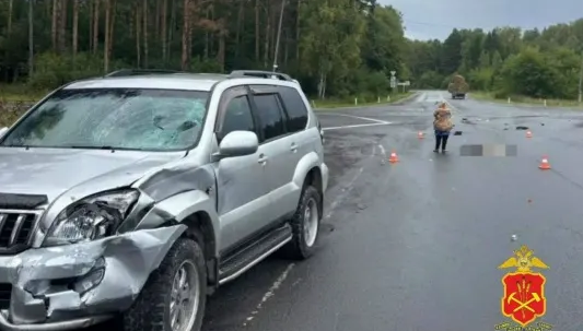 Поврежденный мопед на обочине загородной трассы после столкновения с машиной